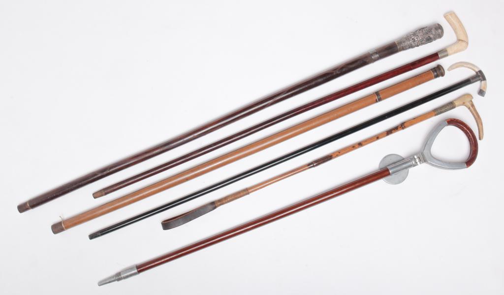SIX WALKING STICKS, GADGET CANES AND RIDING CROP.: American and English, late 19th-early 20th century. Antler handle riding crop, 28"l., ebonized walking stick with boar tusk (repair) and silver fittings with faint English hallmarks, 36.5"l., malacca 