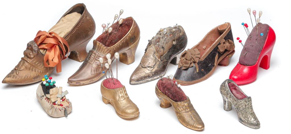 NINE AMERICAN SHOE-SHAPED PINCUSHIONS.: Nineteenth and 20th centuries. Cast white metal, cloth, leather and other material. From 3.5 to 1"h.