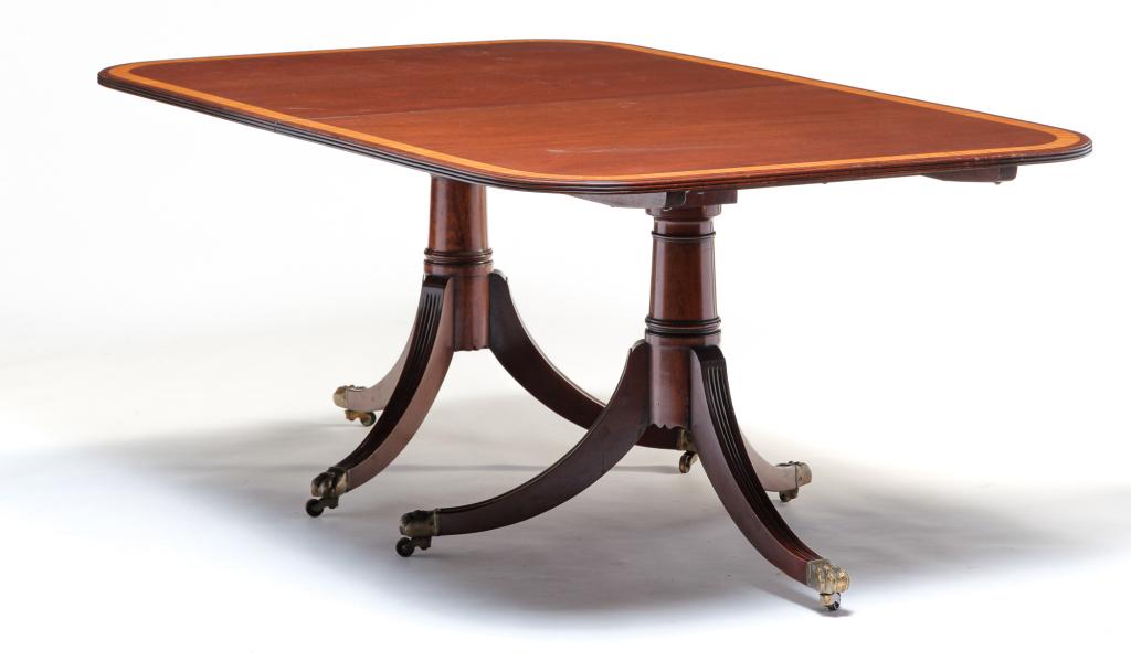AMERICAN DUNCAN PHYFE STYLE DINING TABLE.: Second half 20th century, mahogany. Two part with pedestal bases and reeded saber legs with brass paw feet castors. Banded inlay. Some wear and tiny edge nicks. 29.5"h. 71"w. 45"w. with two 24" leaves