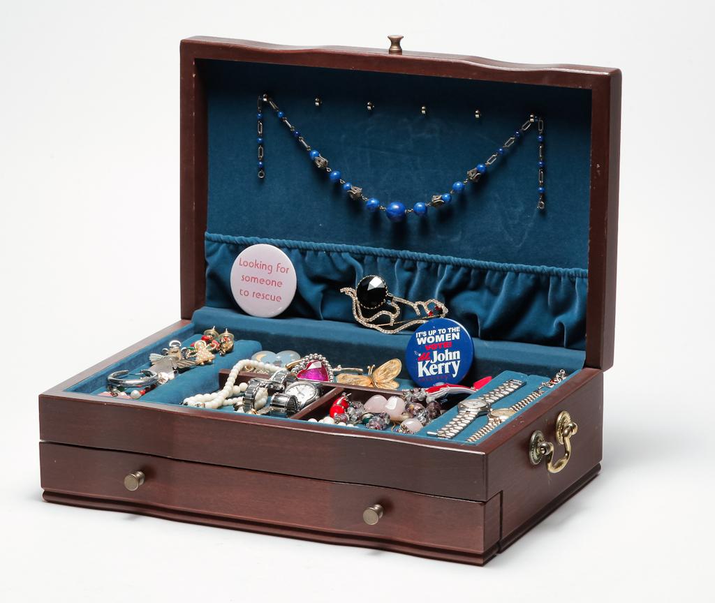 WOODEN JEWELRY BOX WITH COSTUME JEWELRY.: Late 20th -21st century. Wooden box with brass handles and one drawer, filled with assortment of costume jewelry including beads, sweater clips, coral earrings, watches, guardian angel pins, some jewe