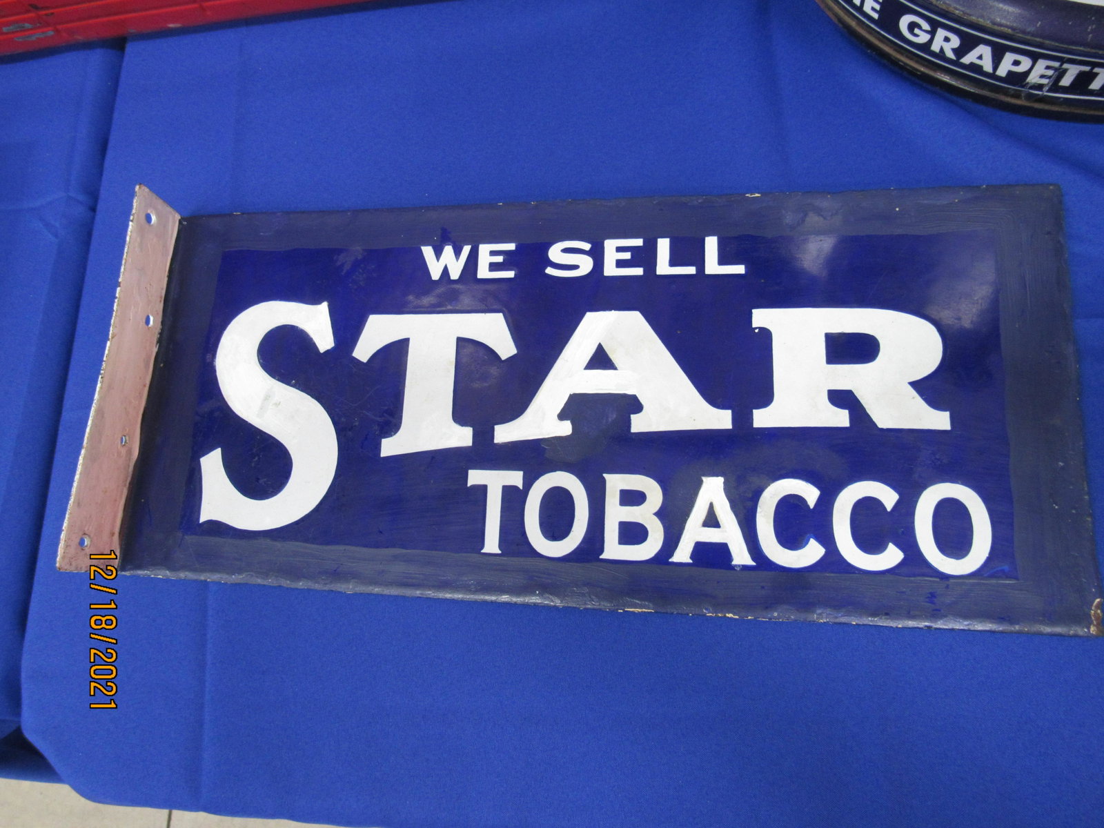 FLANGED STAR TOBACCO SIGN: Mid 20th Century. Porcelain on metal. Repaint and roughness on edges 8”H x 18”W x 2”D