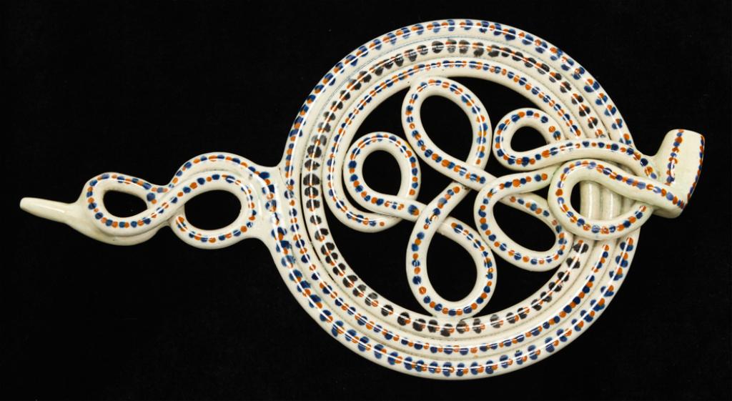 ENGLISH PRATTWARE PUZZLE PIPE.: Late 18th century. Twisted and circular form pipe with ochre and blue decoration. Hairline and repaired lip. 10.5"l. Ex Benjamin Rapaport, author of "Museum of Tobacco Art & History Guide Book".