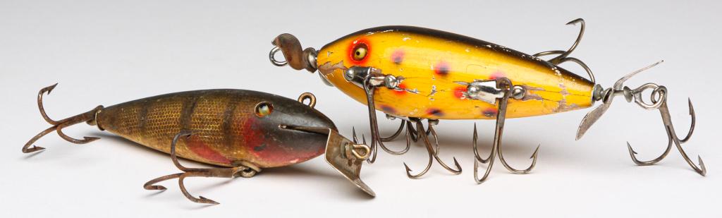 TWO EARLY WOODEN FISHING LURES WITH GLASS EYES.: Two wooden fishing lures with glass eyes. One is a Creek Chub Bait Co. perch wiggler, along with an unmarked lure with spots and six hanging treble hooks.
