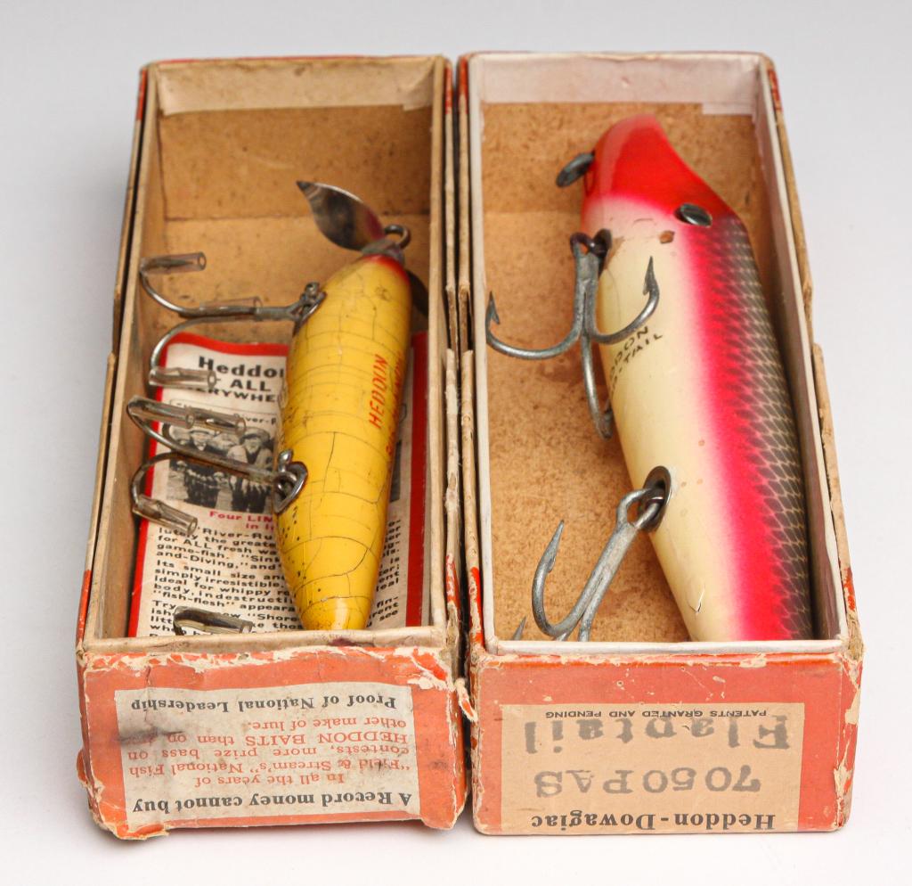 TWO LARGE HEDDON FISHING LURES INCLUDING SOS.: American, first half 20th century. Two large Heddon fishing lures. Includes a Heddon Flap-Tail, 6.75" long, and a Heddon SOS Minnow, 4.5" long. Both are in original boxes, one with paper insert.
