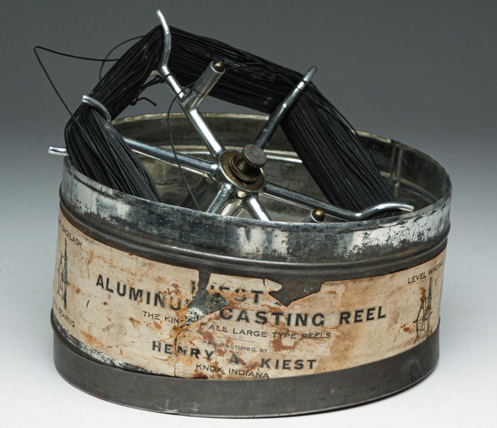 HENRY KIEST INDIANA STYLE FLY REEL WITH TIN BOX.: Mid 20th century. Marked "Henry A. Kiest, Knox, Ind." on reel. Tin box has worn paper label. Minor scratches and nick from use, box has dented rim, 7.25"d.