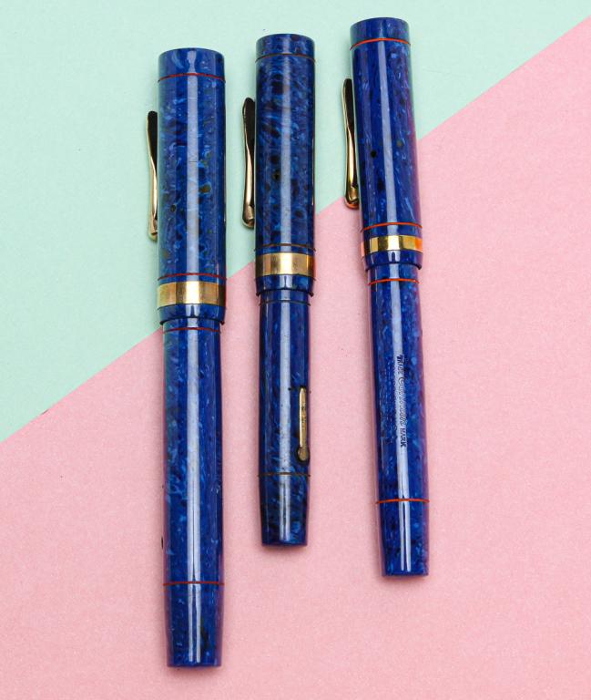 CONKLIN BLUE SAPPHIRE FOUNTAIN PEN - THREE SIZES.: Circa 1925. Three blue sapphire Endura fountain pens, wide gold-filled band and clip, lever-fill. Sizes 5.25", 4.75", and 4.37". Pens stamped on lever 'PAT NOV.17.1925' with embossed crescent, clear b