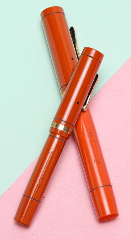 TWO VINTAGE CONKLIN ORANGE FOUNTAIN PENS.: American, circa 1925. Two hard rubber fountain pens, lever fill, both with Endura nibs. Oversize pen, 5.25"l, stamped on lever 'PAT.NOV.17.1925' with embossed crescent, some wear to cap and pen surfac