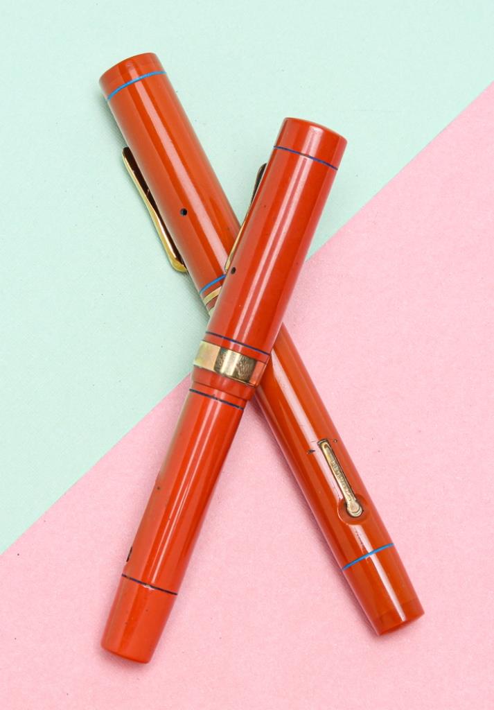 TWO ORANGE CONKLIN ENDURA FOUNTAIN PENS.: American, circa 1925. Two hard rubber fountain pens, lever fill, both with Endura nibs. One pen, 5.0"l, stamped on lever 'PAT.NOV.17.1925' with embossed crescent, double gold filled bands on cap, some