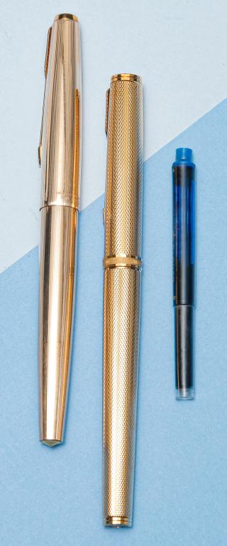 TWO VINTAGE PARKER FOUNTAIN PENS.: 20th century. One Sonnet 23K gold plated laque pen, 18K nib, cartridge/converter filler (with extra cartridge), black stone inset on cap and barrel ends, marked 'Parker France', near mint condition. T