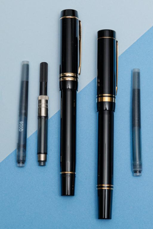 TWO PARKER DUOFOLD FOUNTAIN PENS.: Late 20th century. Two black and gold tone pens: one with Duofold logo on end cap, Duofold 18K nib, marked 'Made in U.K.'; end cap of other pen with seal - initials WAD, 18K nib. Includes Duofold box,