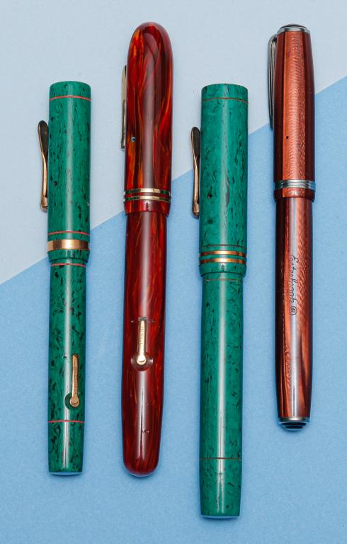 FOUR VINTAGE LEVER FILL FOUNTAIN PENS.: American, mid-20th century. Includes: oversize Conklinbrown wood grain pattern, lever fill, 'Pat. Nov 17 1925' on lever, Conklin nib, 5.5"l; two Conklin green with black marbling Endura lever fill fou