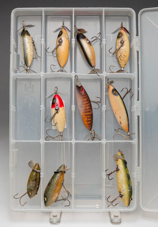 TEN HEDDON FISHING LURES INCLUDING SOS GLASS EYE.: Group of ten Heddon fishing lures. Includes ten S.O.S. lures, five having glass eyes. Included is a Bass Pro Shops clear plastic tackle box.