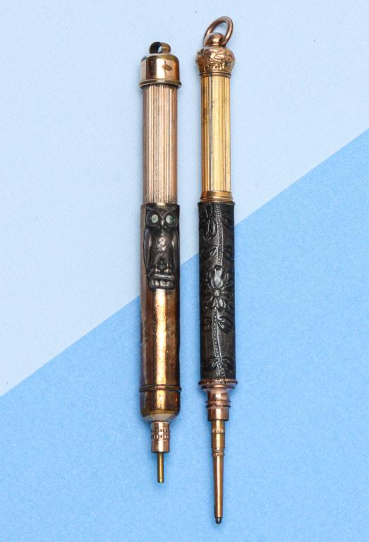 TWO VICTORIAN MIXED METAL "MAGIC" PENCILS.: Late 19th century. Two unusual small retractable pencils: one marked "Aiken-Lambert & Co.", two-tone gold metal body with applied silver metal owl, moon and star, suspension ring missing, approx. 3.12