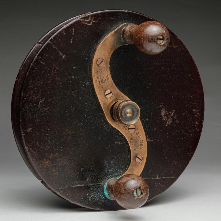 LARGE NEW YORK FISHING REEL.: Late 19th century. Large wooden reel with brass arm marked "Pat'd 1886, G. Ritter New York 237". Damage. 7"d.