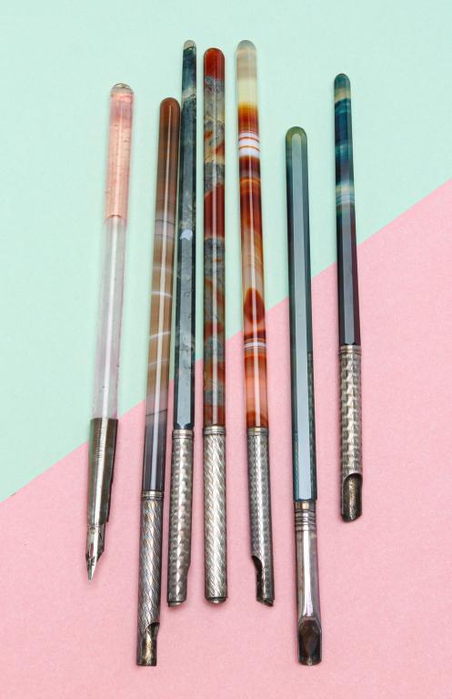 SEVEN VINTAGE GLASS DIP PENS.: Late 19th - early 20th century. Seven dip pens in various colors, two banded agate, with silver or sterling silver etched nib holders, nibs not included with six pens. One collar marked Germany, one s