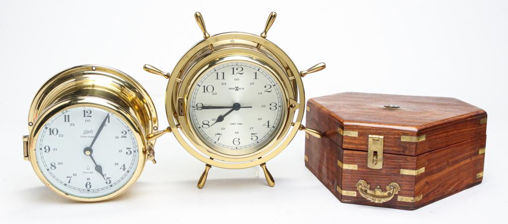 TWO SHIPS' CLOCKS AND A SEXTANT.: Twentieth century. Howard Miller ship's clock with pilot wheel frame, quartz movement and chimes. 10.25"d. Schatz ships' clock, quartz movement and ships' bells chime, 7.25"d. And a contemporary sexta