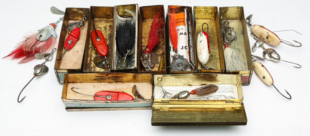 FOURTEEN EARLY AL. FOSS PORK RIND MINNOW LURES.: Group of fourteen Al. Foss pork rind minnow fishing lures. Nine are in original tin boxes, some with paper inserts. Included is a clear plastic tackle box.