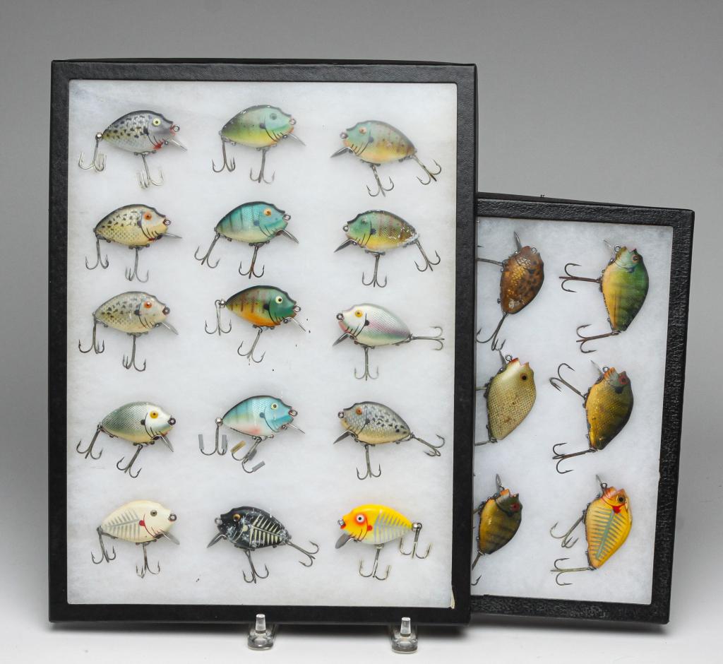 TWENTY-ONE HEDDON PUNKINSEED FISHING LURES.: Group of twenty-one Heddon Punkinseed fishing lures. All are displayed in two glass top cases.