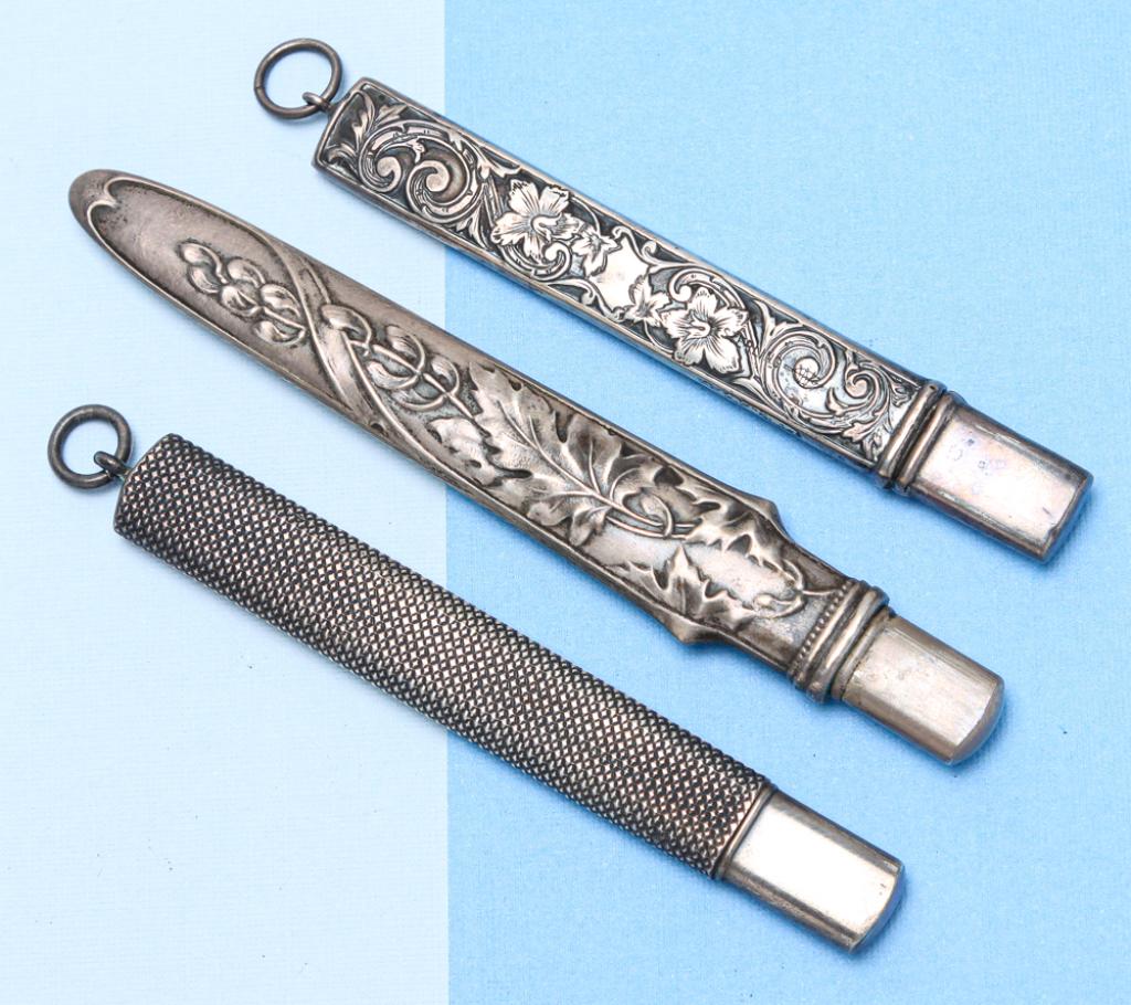 THREE VICTORIAN SILVER PENCIL HOLDERS.: English, 19th century. Three flat pencil holders including: one marked "Sterling" with engine turned decoration, attached suspension ring and pencil, approx. 3"l; one unmarked with floral decoration, 