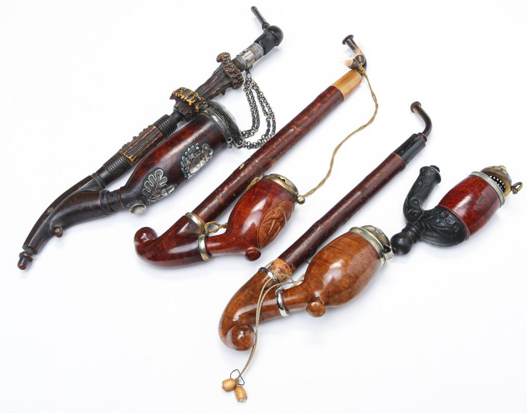 FOUR EUROPEAN WOODEN PIPES AND BOWLS.: Late 19th-early 20th century. Three pipes. Two have branch stems: plain, 10"l. and carved deer, 10.5"l. And one has horn and antler stem with silver initial engraved oak leaf shield and acorn. The lid