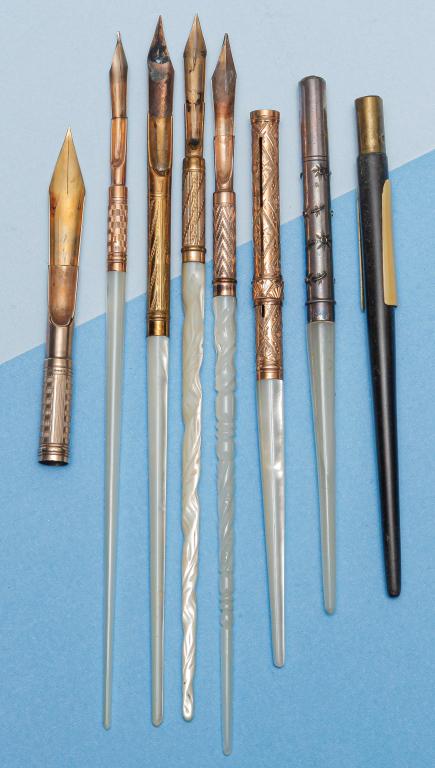 SEVEN VICTORIAN DIP PENS/NIB HOLDERS WITH CASES.: Mid-late 19th century. Five pens with mother-of -pearl handles, chased/engraved grips, one without nib. One pen with sterling silver grip and mother-of-pearl handle. One carved wood pen in worn leathe