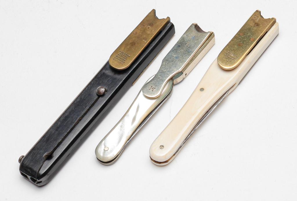 THREE ENGLISH VICTORIAN POCKET QUILL CUTTERS.: Late 19th century. Handles include ebonized wood and mother of pearl. Each has a lift up cutter and a pen knife. Wooden has split and blade doesn't extend. Two marked "Harrison Brothers & Howsen, Cutl