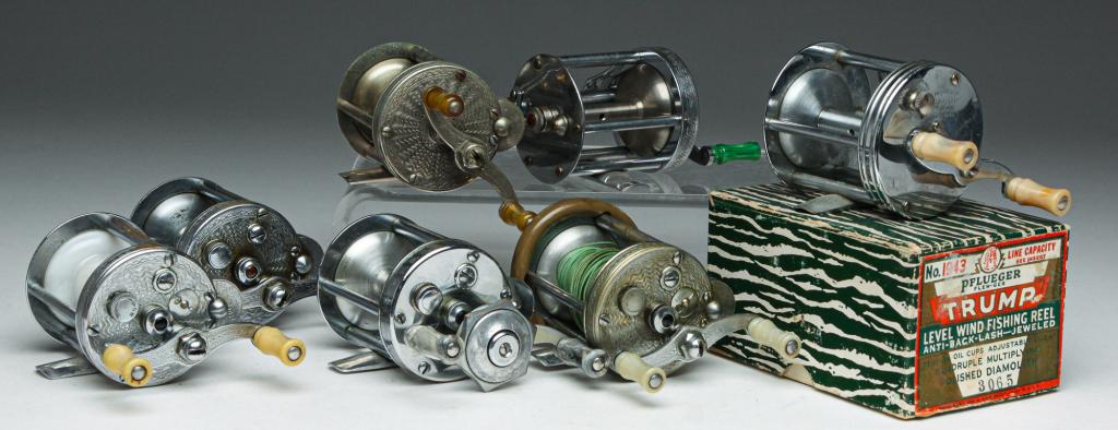 SEVEN "PFLEUGER" BAIT CAST REELS.: Mid 20th century. All have some degree of engraving and probably bakelite handles. Four "Summit" with one having a split rubber ring, two "Akron" and one "Trump" with original box and booklet. Some va