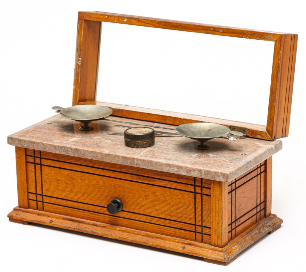 AMERICAN CASED BALANCE SCALES.: Ca. 1900, oak. Incised lines in a geometric pattern, pink marble table and nickel-plated fixtures. 6.75"h. 13.75"w. 6.5"d.