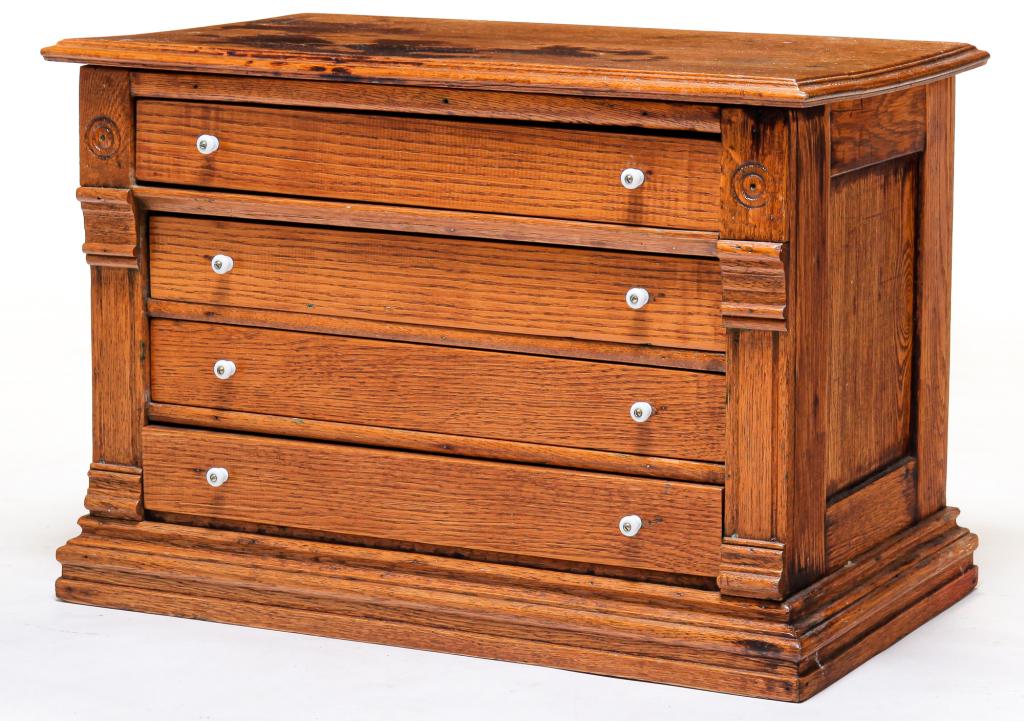 AMERICAN SPOOL CABINET.: Late 19th-early 20th century, oak with pine secondary. Four drawers with mechanical dovetails and original porcelain pulls. Molded edges, pilaster front corners. Cleaned down with traces of red on the