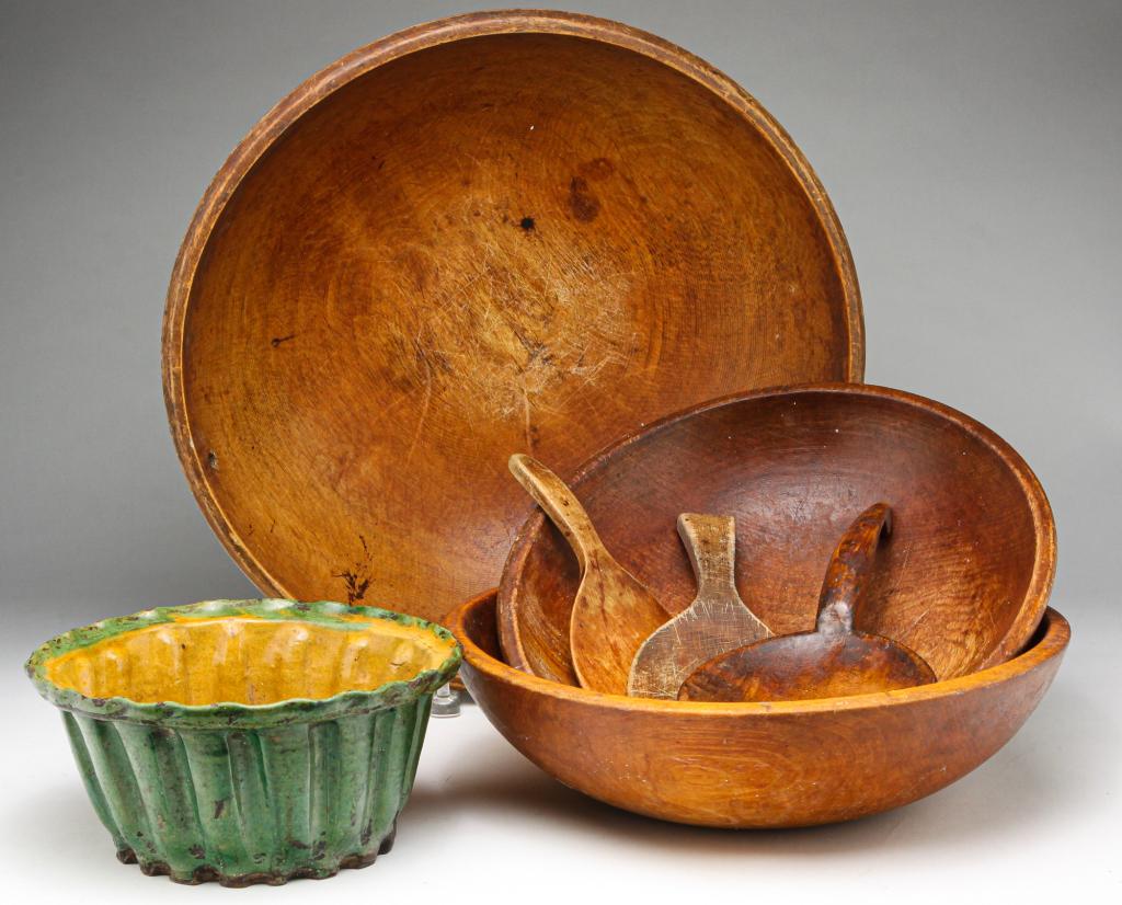 GROUP OF TREENWARE BOWLS, PADDLES AND FOOD MOLD.: Nineteenth century. European redware food mold with green and yellow glaze. Wear, hairlines. 4"h. 9"d. And three American wooden butter paddles and three treenware bowls with varnished surfaces. 3"h.