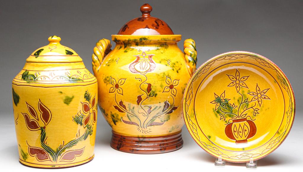 THREE PIECES OF CONTEMPORARY BREININGER REDWARE.: Pennsylvania, late 20th century. Signed and dated. Yellow slip decorated sgraffito designs. Covered jar with handles, 12"h., covered jar, 9.5"h. and bowl, 8"d.