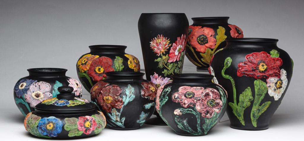 EIGHT PIECES OF TIFFIN BLACK SATIN GLASS.: Mid 20th century. Decorated with brightly painted flowers. Five poppy vases, 5.5"h. Lidded jar, 4"h. Tall footed vase, 11"h.