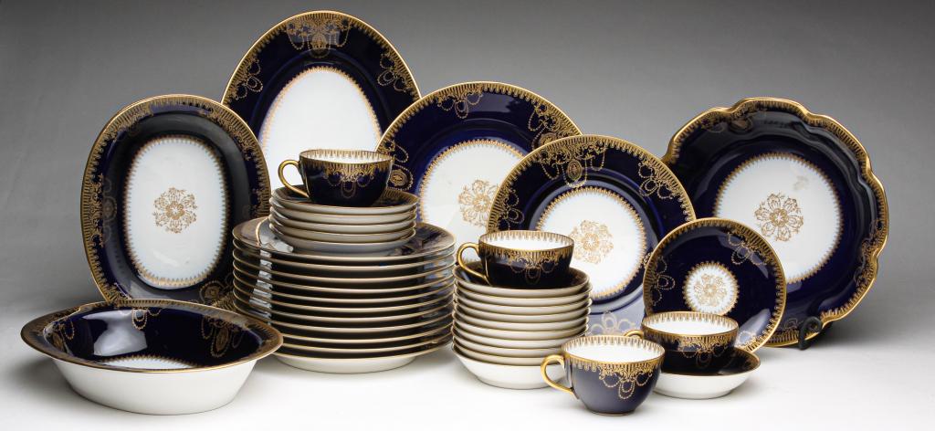 GROUP OF FRENCH HAVILAND CHINA.: Ca. 1900. On the back of some pieces in gold, "Wm Martin, Defiance, Ohio." Cobalt rim with gold rim and Colonial Revival style pattern. Twelve 8.5"d. plates, four cups, six saucers, eleven sauce dishe