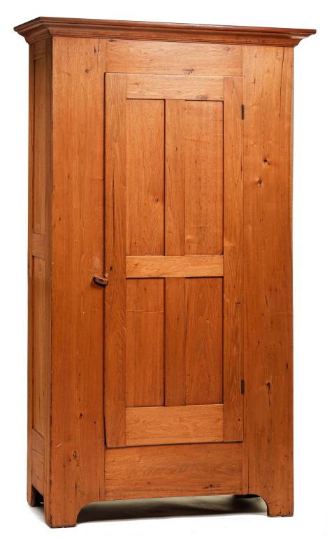 AMERICAN COUNTRY EMPIRE WARDROBE.: Mid 20th century, butternut with poplar secondary. Molded cornice, double-paneled ends, single, overlapping, four-panel door and simple cut-out legs. Refinished with some age cracks. 85"h. 50.5"w. 19.