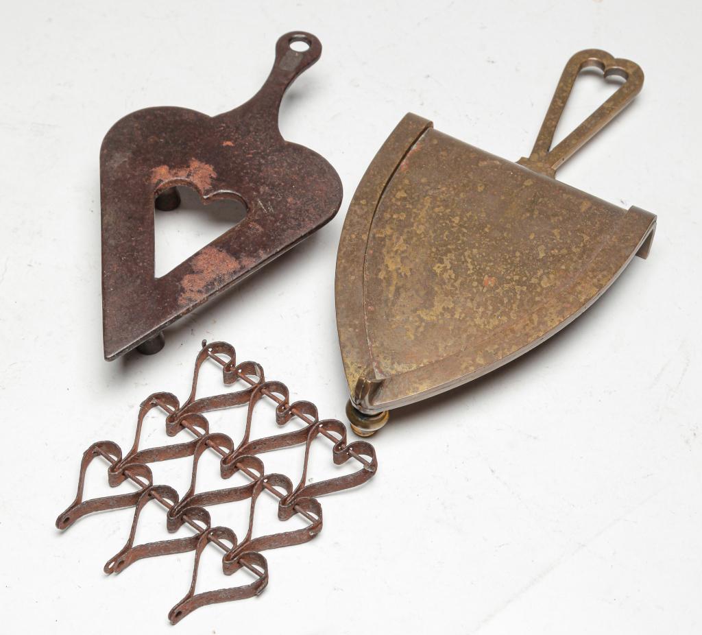 THREE AMERICAN TRIVETS.: Late 19th-early 20th century. Heart shaped. Sheet metal mesh. Incomplete. 5"l., brass for sad iron, 11.5"l. and cst iron. 9"l.