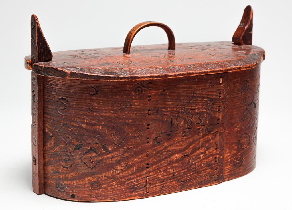 SWEDISH BENTWOOD BOX.: Dated 1883. Bentwood with laced seams, bentwood handle and wooden latches. Punched decoration including flowers and stars. Some wear, missing laces. 8.5"h. 13"l.