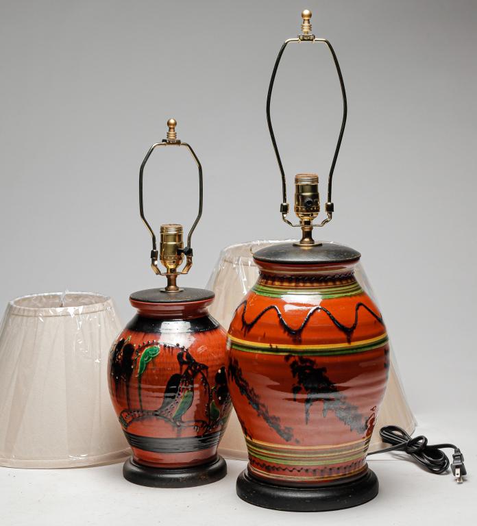 TWO TURTLE CREEK REDWARE TABLE LAMPS.: Ohio, early 21st century. Parrot and flower slip decoration. Signed and dated 2013. 20"h. And sponged manganese with slip bands. Unsigned. 26"h. Includes harps and shades. From the work shops of David