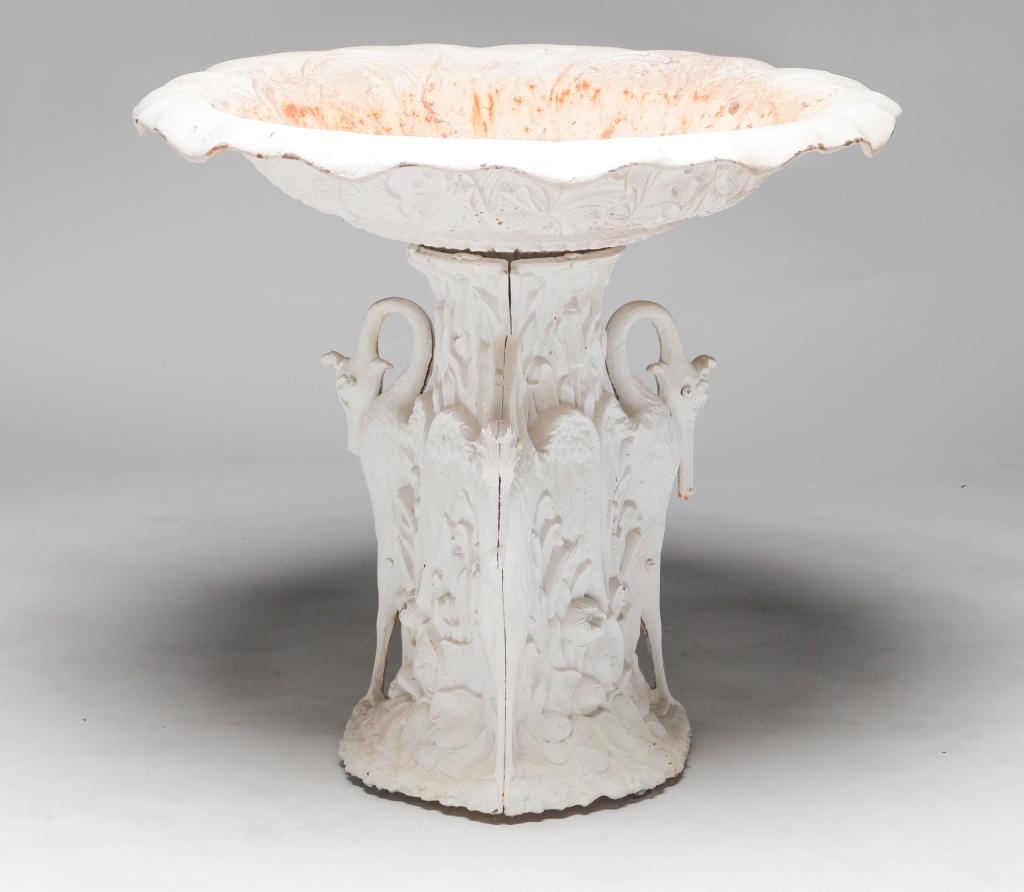 AMERICAN CAST IRON GARDEN FOUNTAIN.: Early 20th century. Two piece with cast ivy decorated bowl with scalloped rim and an ivy covered base with three stylized cranes. Layers of old, rusty white paint and two ground down areas on the top 