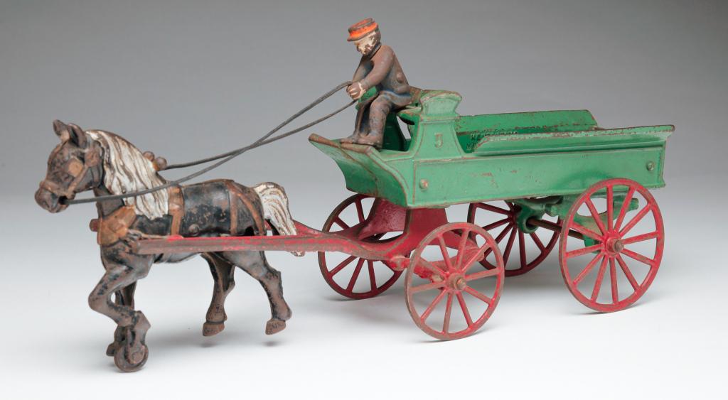 AMERICAN KENTON HORSE AND WAGON TOY.: First half 20th century, cast iron. Original paint with replaced reins. Marked inside bed "Kenton Toys, Made in USA." Some wear and rust. 7"h. 3.5"w. 14.5"l.