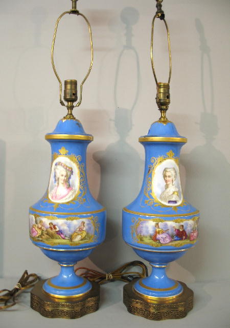 TWO HAND PAINTED PORCELAIN LAMPS. Light blue table: TWO HAND PAINTED PORCELAIN LAMPS. Light blue table lamps with hand painted flowers and white reserves with portraits of women and idyllic scenes of troubadors and shepherds. Brass bases and hand paint