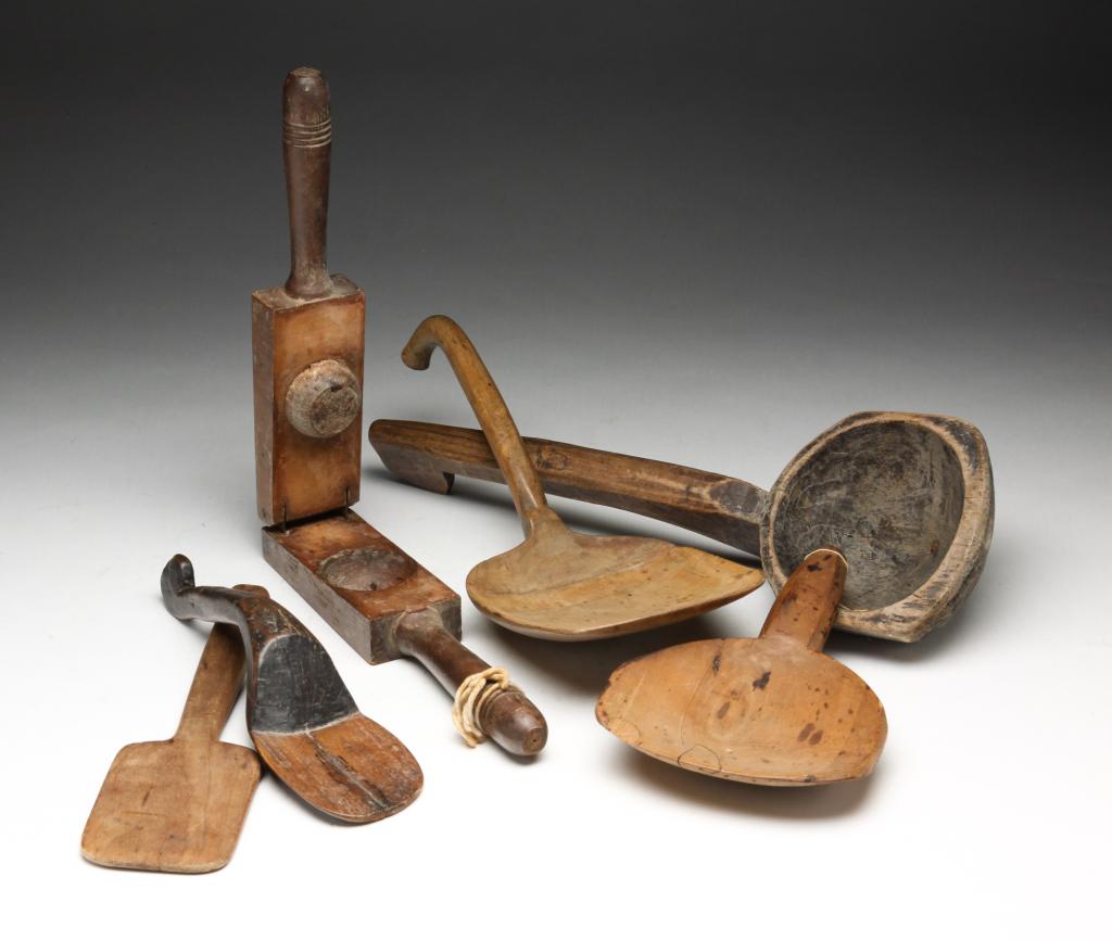SIX AMERICAN WOODEN UTENSILS.: Nineteenth-early 20th century. Butter paddles, spatulas, scoop with old black paint and a lemon squeezer. Varying wear and repaired paddle. 9.25" to 14.25"l.