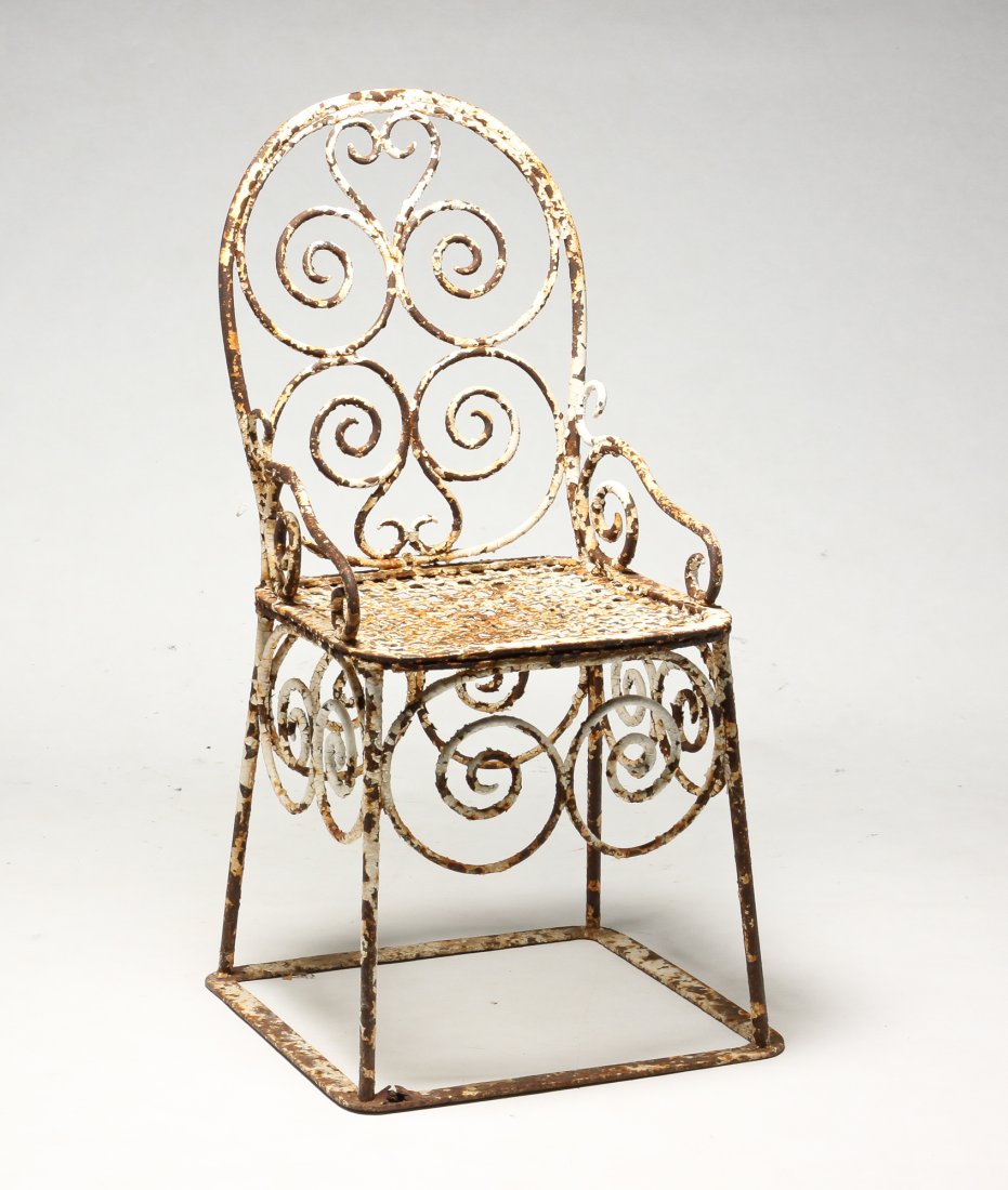 AMERICAN WROUGHT IRON GARDEN ARMCHAIR.: Early 20th century. Scrolled designs and lattice seat. Rust with worn layers of white paint. 19" seat, 39"h.