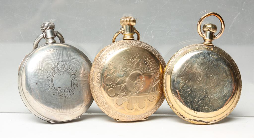 THREE VINTAGE HUNTING CASE POCKET WATCHES.: American, late 19th century. Three watches including: 18S, 7J, lever set in Champion coin silver case, wear to case, retailed A.M. Hill, New Orleans, the enamel dial with Roman numerals, the face and