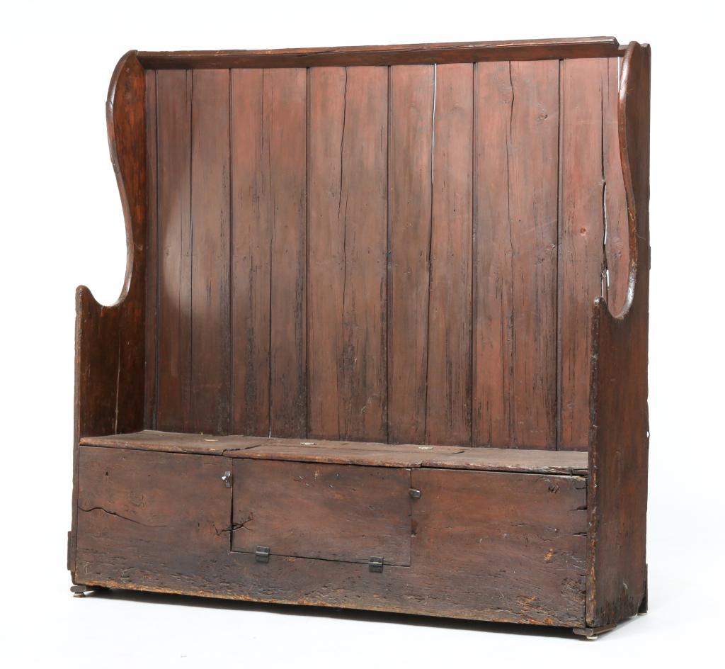 ENGLISH FIRESIDE BENCH.: Late 18th, early 19th century, pine. High back, shaped ends with scooped arms, back boards with beaded edge, seat with hinged lid section of center over a hinged drop panel in front. Refinished, some 