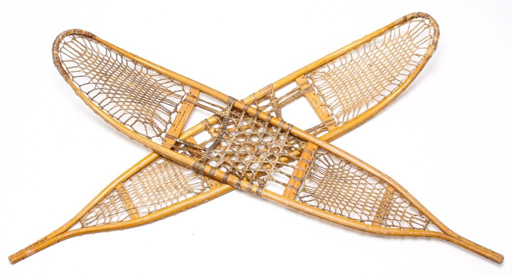 TWO AMERICAN WWII MILITARY SNOWSHOES.: Labeled for Abercrombie & Fitch Holding Company, Wallingford, Connecticut, 1942 and 1943. Wooden frames with rawhide lacing. Near pair with same stamped size 10 x 58, differing production numbers (one
