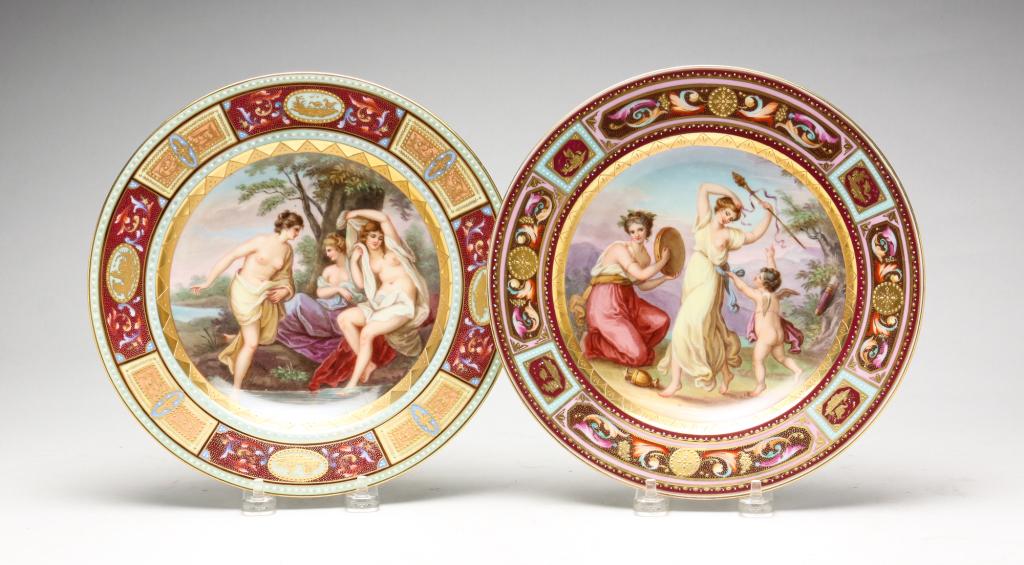 TWO ROYAL VIENNA HAND PAINTED PORCELAIN PLATES.: Austria, second half 19th century. Classical and romantic scenes depicting women and a cupid. Enameling, heavy gold with floral reserves. Blue bee hive mark. 9.25" diameter.