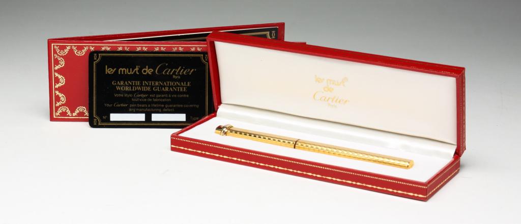 LES MUST DE CARTIER BALL POINT PEN.: France, 2nd. half - 20th century. Gold tone ball point pen, pen body and cap with textured surface, stamped Plaque Or G / Made in France / Cartier Paris and with interlocking C's mark, numbered 457275