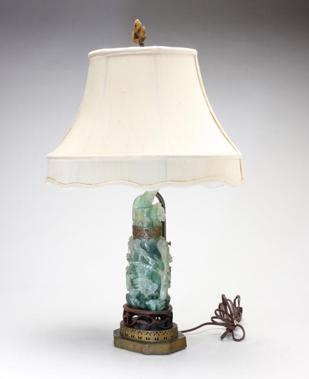 ASIAN CARVED GREEN STONE LAMP.: Twentieth century. Carved two piece sone lamp with birds. Carving sits on wood openwork piece atop a brass stepped base. Wear and loss to carving. 11.75"h without harp.