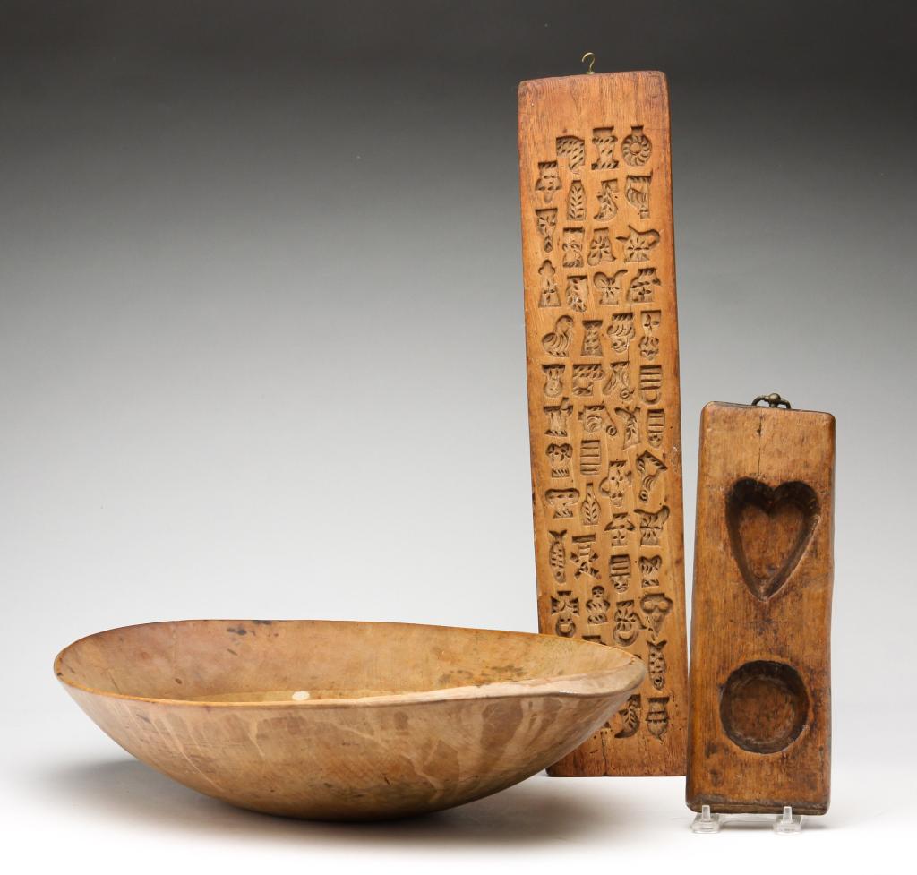 AMERICAN WOOD TRENCHER AND MOLDS.: Nineteenth century. Ovoid trencher, 22.5"l x 13.75"w, an animal and figural cookie mold, 21.75"l and a heart and circle maple syrup mold, 11.25"l 4"w. Varying wear.
