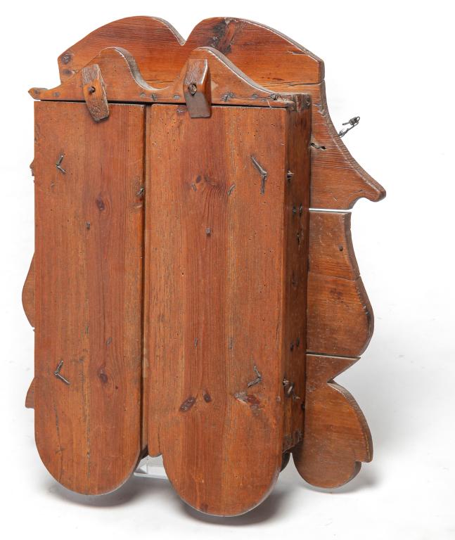 HANGING CABINET.: Eighteenth-19th century. Pine and wormwood cabinet. Decorative scalloped back boards with iron nails below and a two door dovetailed cabinet with spoon racks inside. Wrought iron nails with later adde